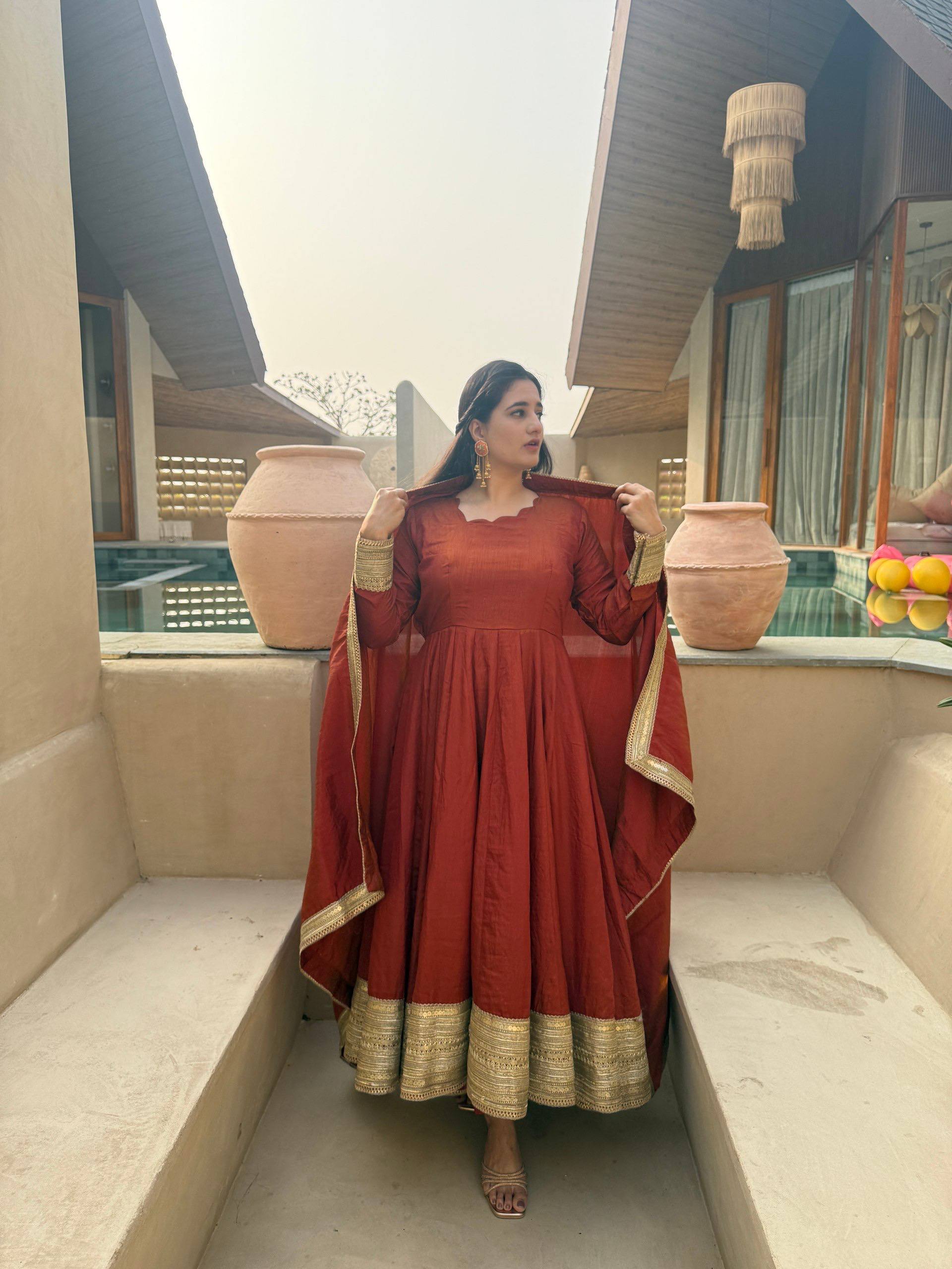 Regal Rust Orange Flared Anarkali Suit Set Featuring Ornate Gold Sequined Borders, a Scalloped Neckline, and an Elegant Tie-Up Back